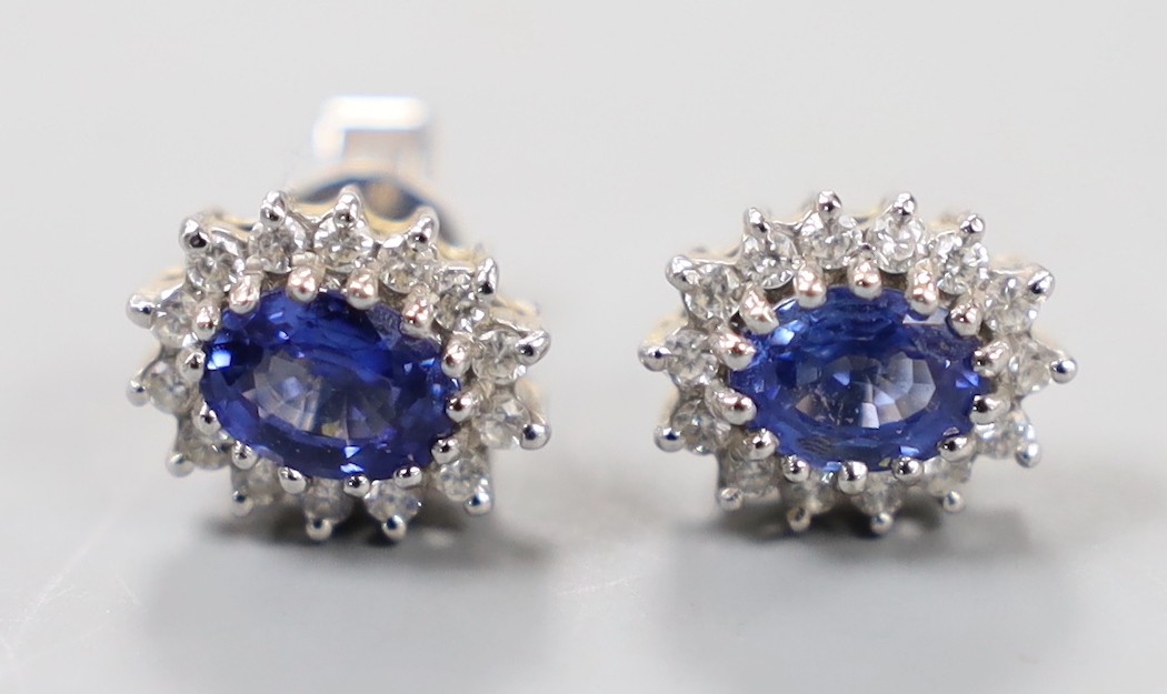 A modern pair of 750 white metal, sapphire and diamond set oval cluster earrings, length 10mm, gross weight 4.1 grams (one butterfly missing).